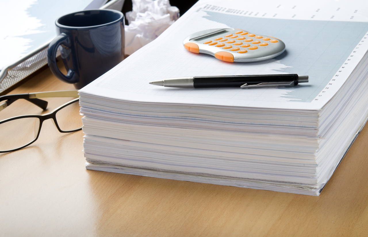 A-pile-of-paperwork-with-a-calculator-and-pen-on-top-185039450_4926x3176