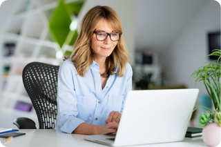 woman in blue shirt sitting at a computer